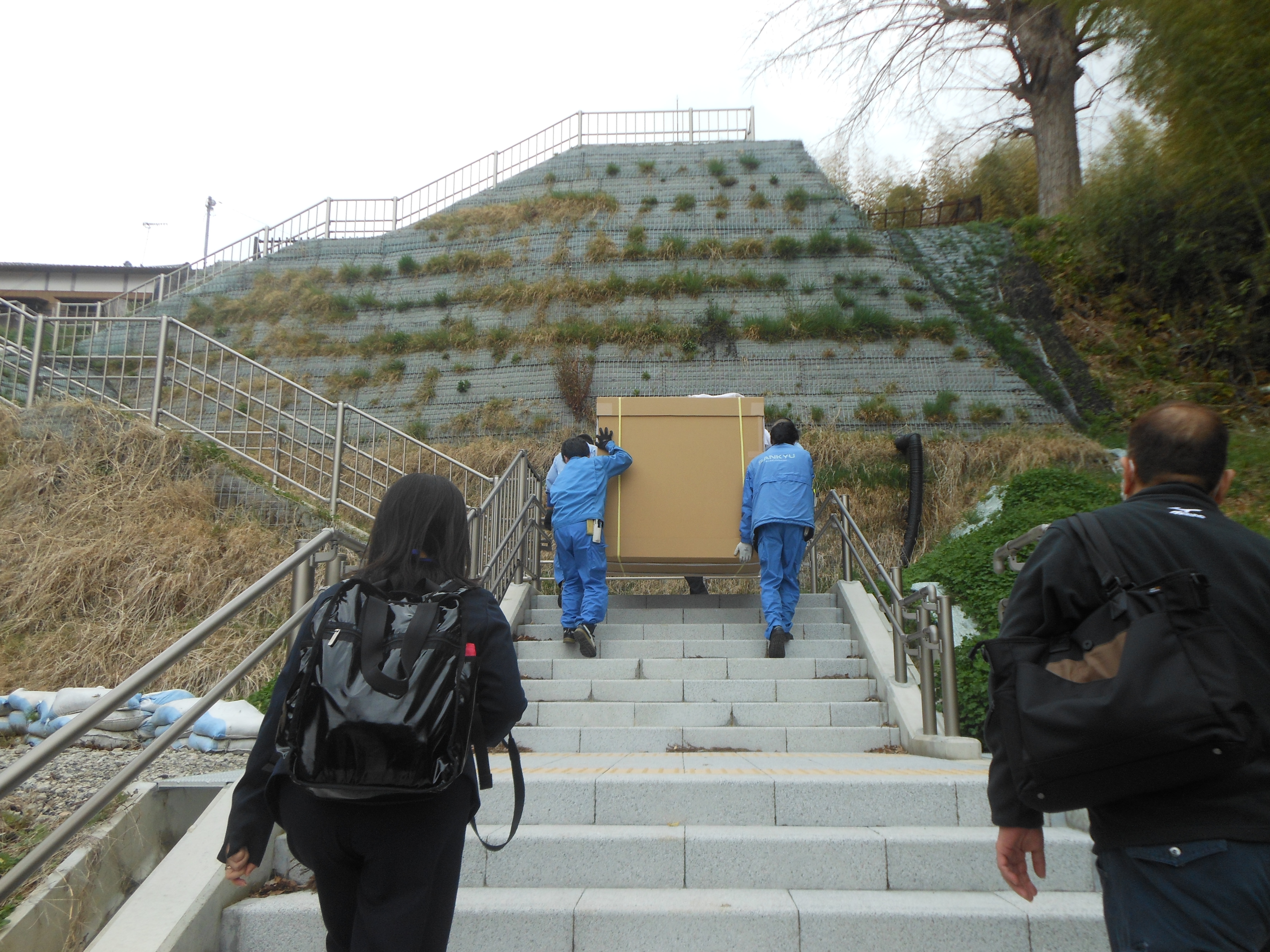 階段を四人がかりで遥かかなたの山頂に運び上げる　大変